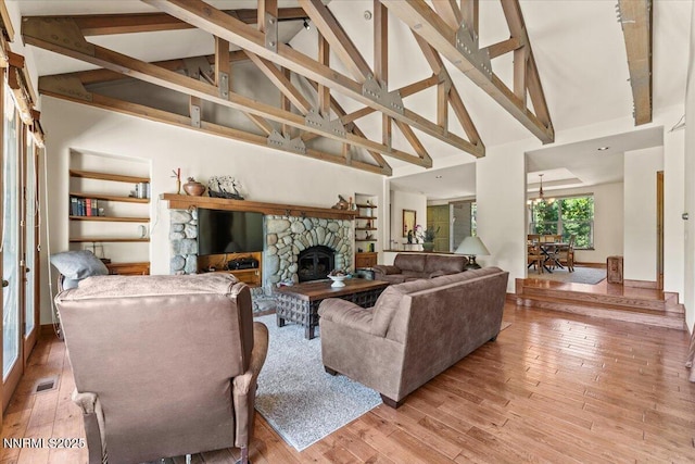 6195 Philoree Ln, Reno, NV 89511 - living area with high vaulted ceiling, a stone fireplace, wood finished floors, and beamed ceiling