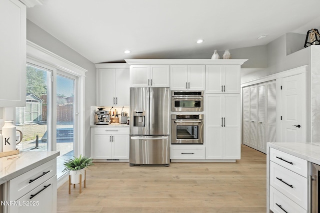 5863 Foggy Ct, Sun Valley, NV 89433 - kitchen with stainless steel appliances, light wood-type flooring, white cabinetry, light stone countertops, and recessed lighting