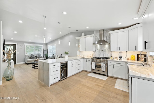 5863 Foggy Ct, Sun Valley, NV 89433 - kitchen featuring high end range, wall chimney exhaust hood, beverage cooler, a peninsula, and recessed lighting