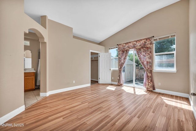 7449 Ambush Cir, Sparks, NV 89436 - spare room featuring arched walkways, light wood-style flooring, and high vaulted ceiling