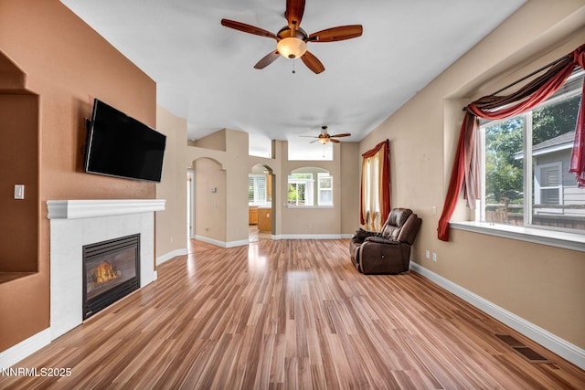 7449 Ambush Cir, Sparks, NV 89436 - unfurnished living room with healthy amount of natural light, wood finished floors, a tile fireplace, and a ceiling fan