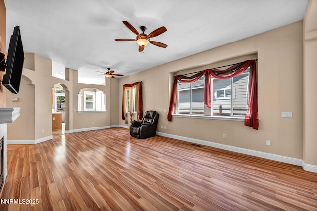7449 Ambush Cir, Sparks, NV 89436 - unfurnished room featuring arched walkways, healthy amount of natural light, a ceiling fan, and light wood-type flooring