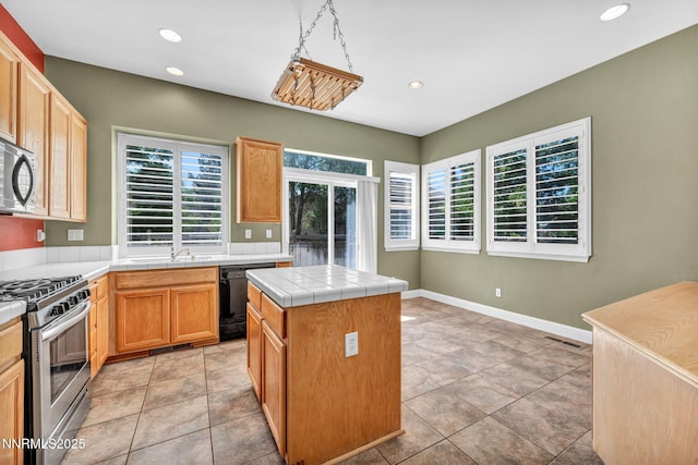 7449 Ambush Cir, Sparks, NV 89436 - kitchen with stainless steel appliances, tile countertops, recessed lighting, and a center island