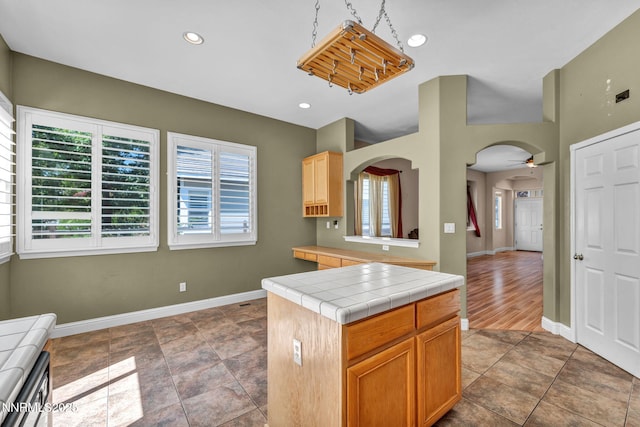7449 Ambush Cir, Sparks, NV 89436 - kitchen featuring tile counters, arched walkways, recessed lighting, and a ceiling fan