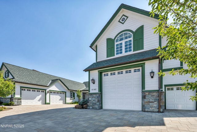 6145 Triple Crown Dr, Reno, NV 89511 - view of front of home featuring stone siding, decorative driveway, and a garage