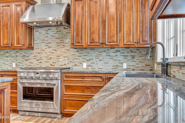 6145 Triple Crown Dr, Reno, NV 89511 - kitchen featuring high end stainless steel range oven, range hood, brown cabinetry, and decorative backsplash