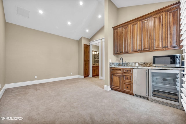 6145 Triple Crown Dr, Reno, NV 89511 - bar with beverage cooler, stainless steel microwave, lofted ceiling, light colored carpet, and refrigerator