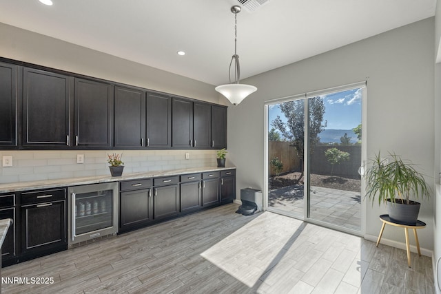 9435 Stony Hill Rd, Reno, NV 89521 - kitchen featuring beverage cooler, backsplash, light wood-style flooring, hanging light fixtures, and recessed lighting