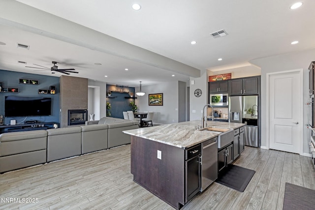 9435 Stony Hill Rd, Reno, NV 89521 - kitchen featuring stainless steel appliances, light wood-style floors, light stone counters, dark brown cabinets, and recessed lighting