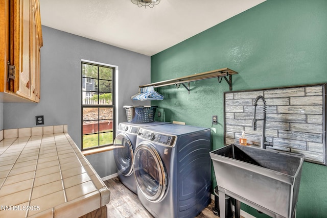 3279 Upland Ct, Carson City, NV 89703 - laundry room with washer and clothes dryer, cabinet space, wood finished floors, and a textured wall