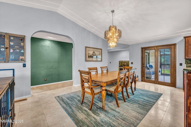 3279 Upland Ct, Carson City, NV 89703 - dining room with arched walkways, vaulted ceiling, a chandelier, light tile patterned floors, and french doors