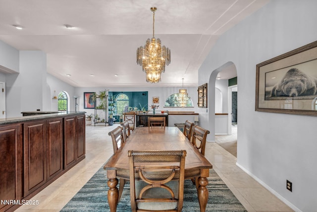 3279 Upland Ct, Carson City, NV 89703 - dining room featuring arched walkways, light tile patterned flooring, a chandelier, and vaulted ceiling
