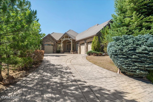 4990 Mountainshyre Rd, Reno, NV 89519 - tudor-style house featuring stone siding, a garage, and driveway
