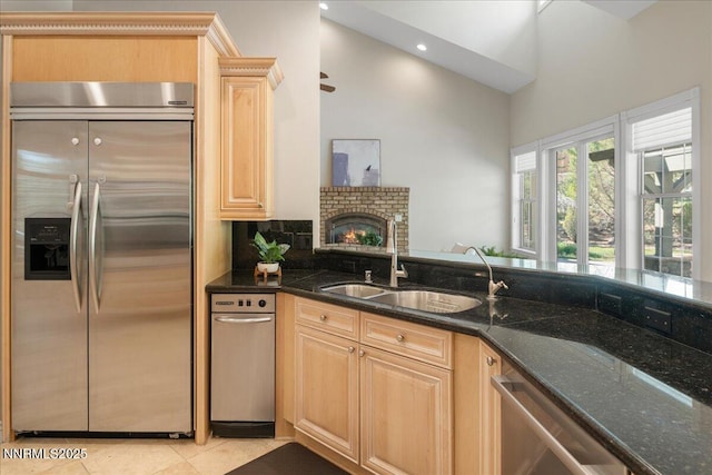 4990 Mountainshyre Rd, Reno, NV 89519 - kitchen with appliances with stainless steel finishes, light brown cabinetry, dark stone countertops, a towering ceiling, and light tile patterned flooring