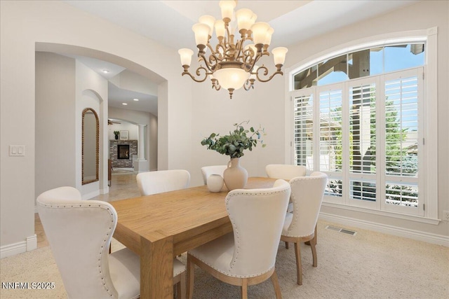 4990 Mountainshyre Rd, Reno, NV 89519 - dining room with arched walkways, a chandelier, light carpet, recessed lighting, and a fireplace