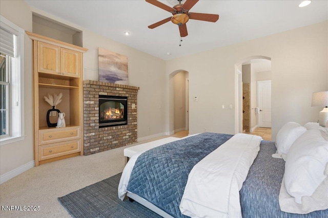 4990 Mountainshyre Rd, Reno, NV 89519 - bedroom featuring arched walkways, light colored carpet, recessed lighting, a fireplace, and a ceiling fan