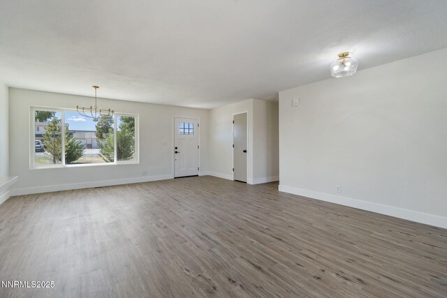 684 Carson River Dr, Fallon, NV 89406 - unfurnished living room with wood finished floors, a chandelier, and healthy amount of natural light