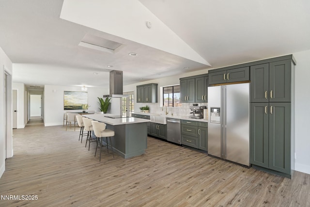 684 Carson River Dr, Fallon, NV 89406 - kitchen with appliances with stainless steel finishes, island range hood, a breakfast bar, light countertops, and a kitchen island