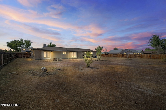 684 Carson River Dr, Fallon, NV 89406 - back of property at dusk with a fenced backyard and a chimney