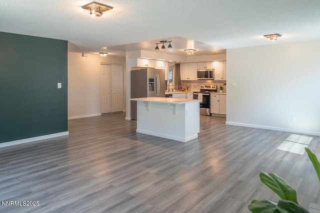 875 Camino Real Dr, Sparks, NV 89434 - kitchen with appliances with stainless steel finishes, white cabinetry, light countertops, backsplash, and a kitchen bar