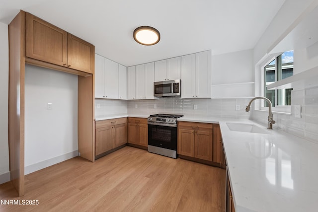 1305 Gault Way, Sparks, NV 89431 - kitchen with stainless steel appliances, open shelves, light wood finished floors, tasteful backsplash, and brown cabinets