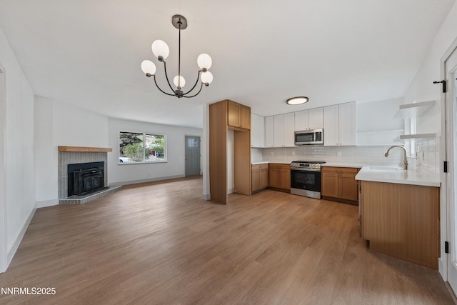 1305 Gault Way, Sparks, NV 89431 - kitchen featuring appliances with stainless steel finishes, open shelves, open floor plan, light wood finished floors, and decorative backsplash