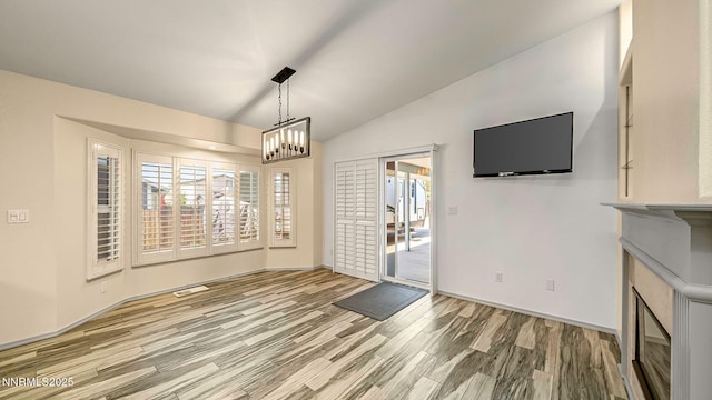 2015 Flycatcher Dr, Spanish Springs, NV 89441 - unfurnished dining area featuring wood finished floors, vaulted ceiling, and a chandelier