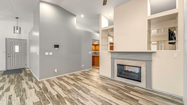 2015 Flycatcher Dr, Spanish Springs, NV 89441 - unfurnished living room featuring high vaulted ceiling, wood finished floors, a multi sided fireplace, and recessed lighting