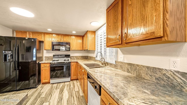 2015 Flycatcher Dr, Spanish Springs, NV 89441 - kitchen featuring black appliances, light wood-type flooring, brown cabinetry, recessed lighting, and light stone countertops