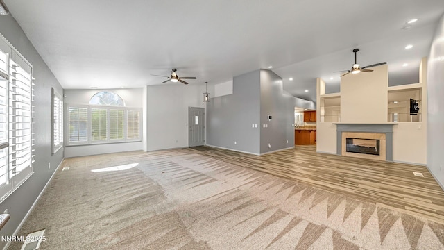 2015 Flycatcher Dr, Spanish Springs, NV 89441 - unfurnished living room with a ceiling fan, carpet, a glass covered fireplace, recessed lighting, and lofted ceiling