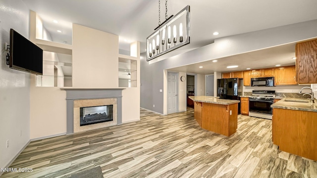 2015 Flycatcher Dr, Spanish Springs, NV 89441 - kitchen featuring black appliances, a kitchen island, recessed lighting, brown cabinets, and open floor plan