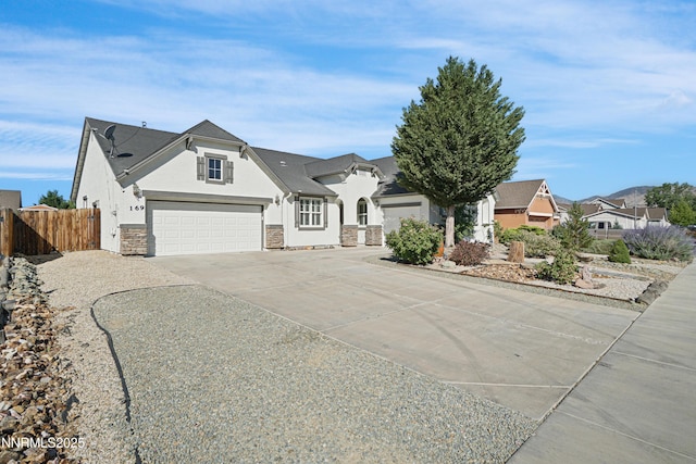 169 Oakridge Dr, Dayton, NV 89403 - view of front of home with stucco siding, concrete driveway, an attached garage, and stone siding