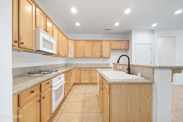 169 Oakridge Dr, Dayton, NV 89403 - kitchen featuring white appliances, light tile patterned floors, light brown cabinets, recessed lighting, and an island with sink