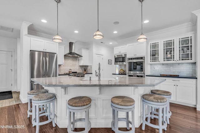 600 Artemesia Ln, Gardnerville, NV 89460 - kitchen featuring appliances with stainless steel finishes, wall chimney range hood, white cabinetry, decorative backsplash, and recessed lighting