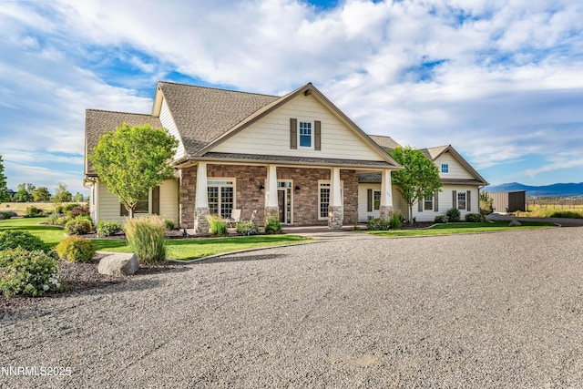 600 Artemesia Ln, Gardnerville, NV 89460 - craftsman inspired home featuring covered porch, roof with shingles, stone siding, and a front lawn
