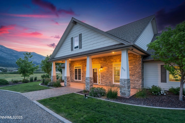 600 Artemesia Ln, Gardnerville, NV 89460 - craftsman-style home with covered porch, a mountain view, a shingled roof, stone siding, and a yard