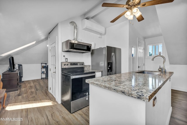911 F St, Sparks, NV 89431 - kitchen with appliances with stainless steel finishes, a wall mounted air conditioner, wood finished floors, ceiling fan, and beam ceiling
