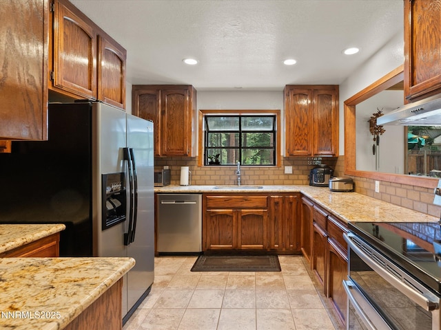 139 Rosewood Cir, Stateline, NV 89449 - kitchen featuring appliances with stainless steel finishes, backsplash, brown cabinetry, recessed lighting, and under cabinet range hood