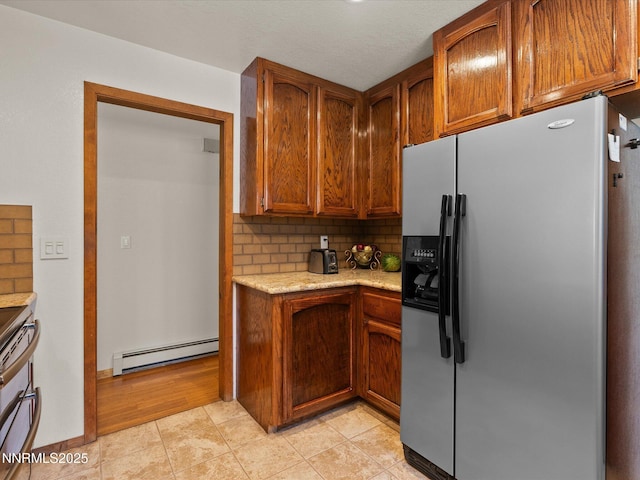 139 Rosewood Cir, Stateline, NV 89449 - kitchen featuring stainless steel refrigerator with ice dispenser, a baseboard heating unit, decorative backsplash, brown cabinetry, and range