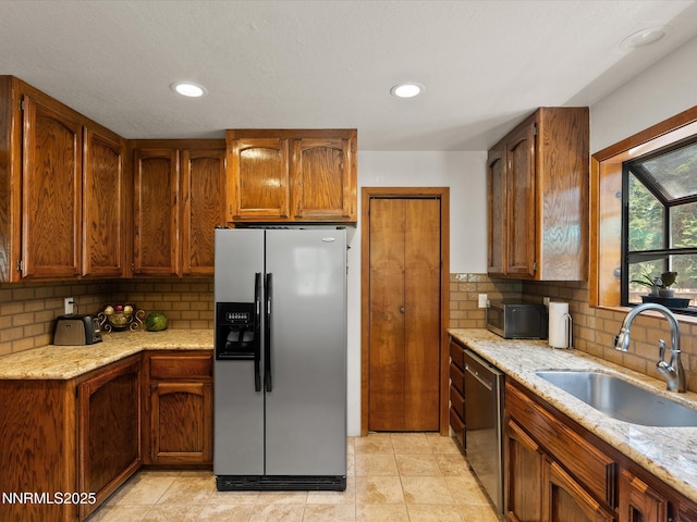 139 Rosewood Cir, Stateline, NV 89449 - kitchen featuring appliances with stainless steel finishes, decorative backsplash, recessed lighting, brown cabinets, and light stone countertops