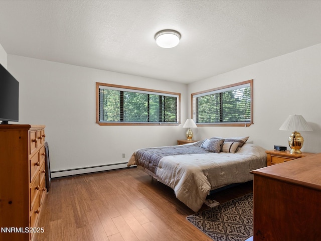 139 Rosewood Cir, Stateline, NV 89449 - bedroom featuring baseboard heating, wood finished floors, and a textured ceiling