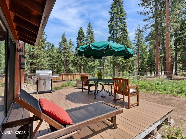 139 Rosewood Cir, Stateline, NV 89449 - wooden deck featuring outdoor dining space, grilling area, a fenced backyard, and view of wooded area