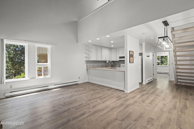 807 Alder Ave Unit 14, Incline Village, NV 89451 - kitchen with white appliances, a baseboard heating unit, white cabinets, open shelves, and light wood-style flooring