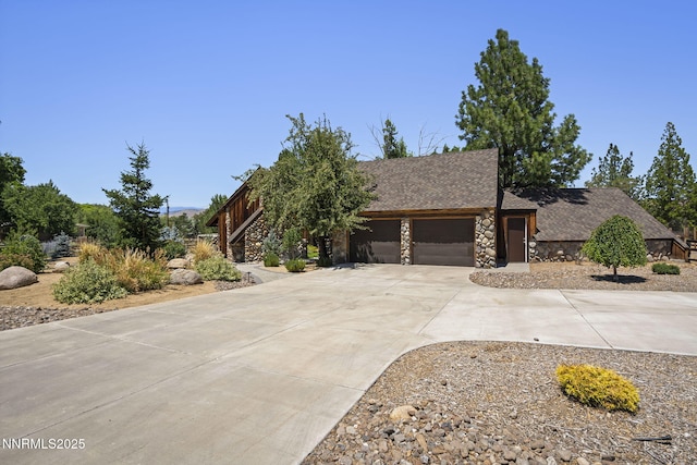 4275 Juniper Creek Rd, Reno, NV 89519 - view of property hidden behind natural elements with stone siding, driveway, a garage, and roof with shingles