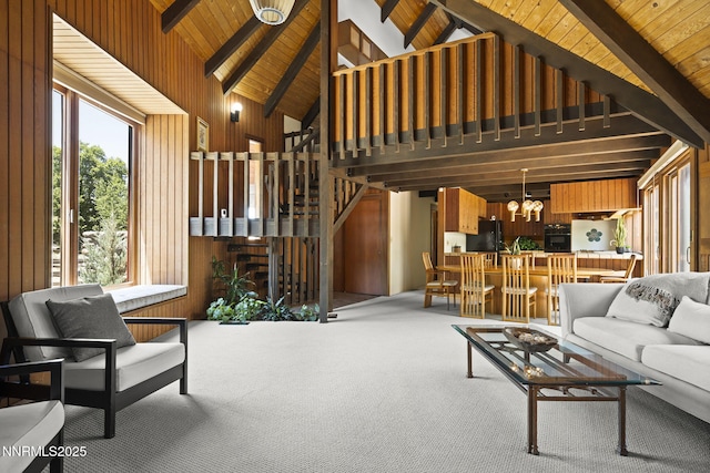 4275 Juniper Creek Rd, Reno, NV 89519 - carpeted living area featuring high vaulted ceiling, a wooden ceiling with exposed beams, a chandelier, wood walls, and stairway