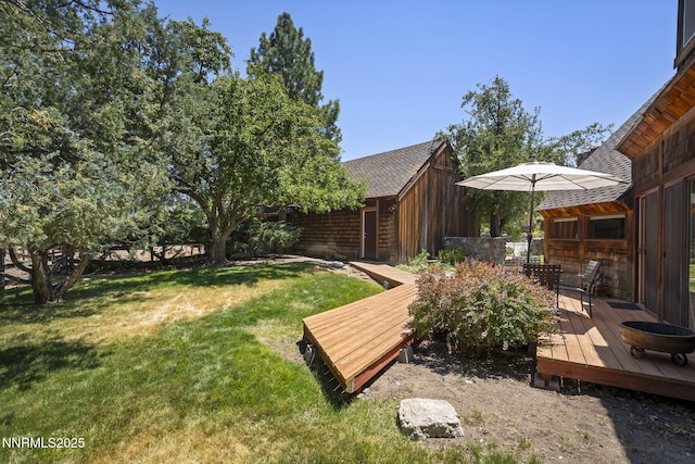 4275 Juniper Creek Rd, Reno, NV 89519 - view of grassy yard with a wooden deck, outdoor dining area, and an outbuilding