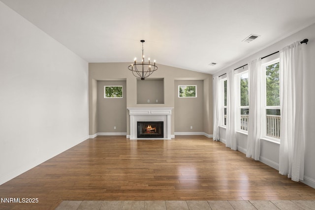 4833 Ramcreek Trl, Reno, NV 89519 - unfurnished living room featuring hardwood / wood-style flooring, a chandelier, a fireplace with flush hearth, and lofted ceiling