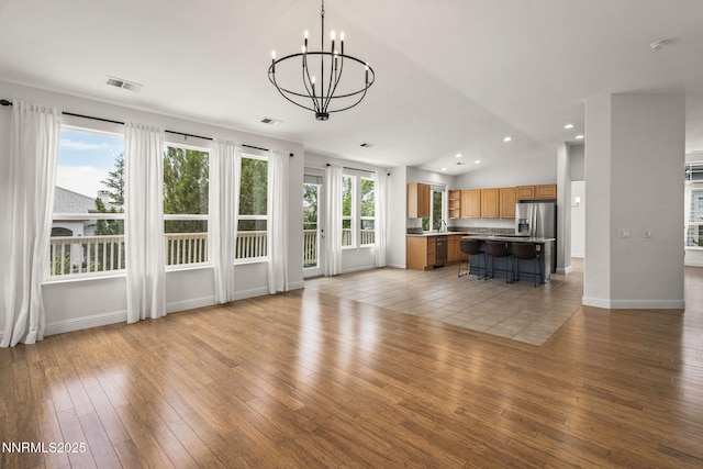 4833 Ramcreek Trl, Reno, NV 89519 - unfurnished living room with a chandelier, light wood-style floors, vaulted ceiling, and recessed lighting