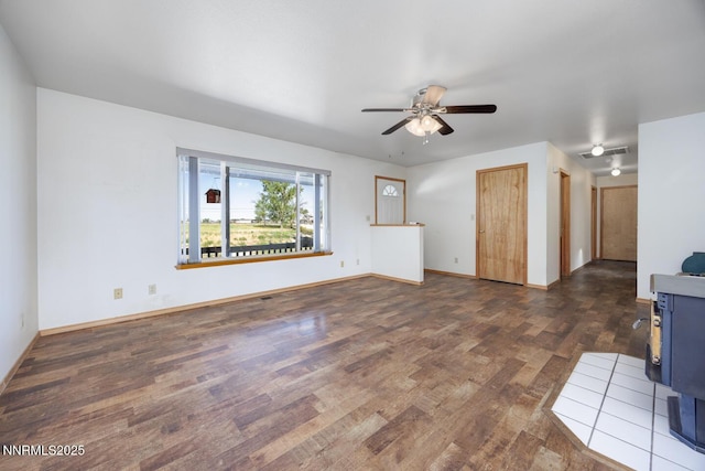 4625 Schurz Hwy, Fallon, NV 89406 - unfurnished living room featuring dark wood-style floors, a ceiling fan, and a wood stove
