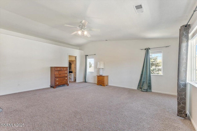 18324 Dustin Ct, Reno, NV 89508 - unfurnished bedroom with light colored carpet, multiple windows, vaulted ceiling, a ceiling fan, and a walk in closet